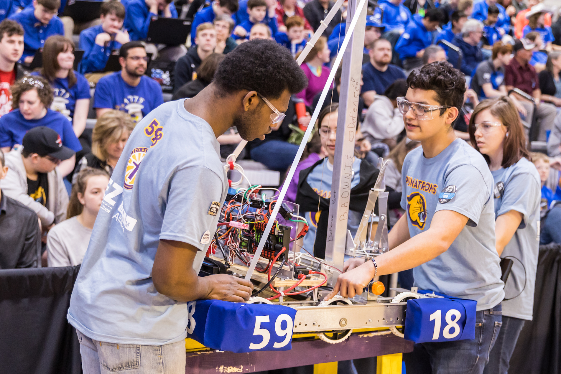 Two teen boys holding robot